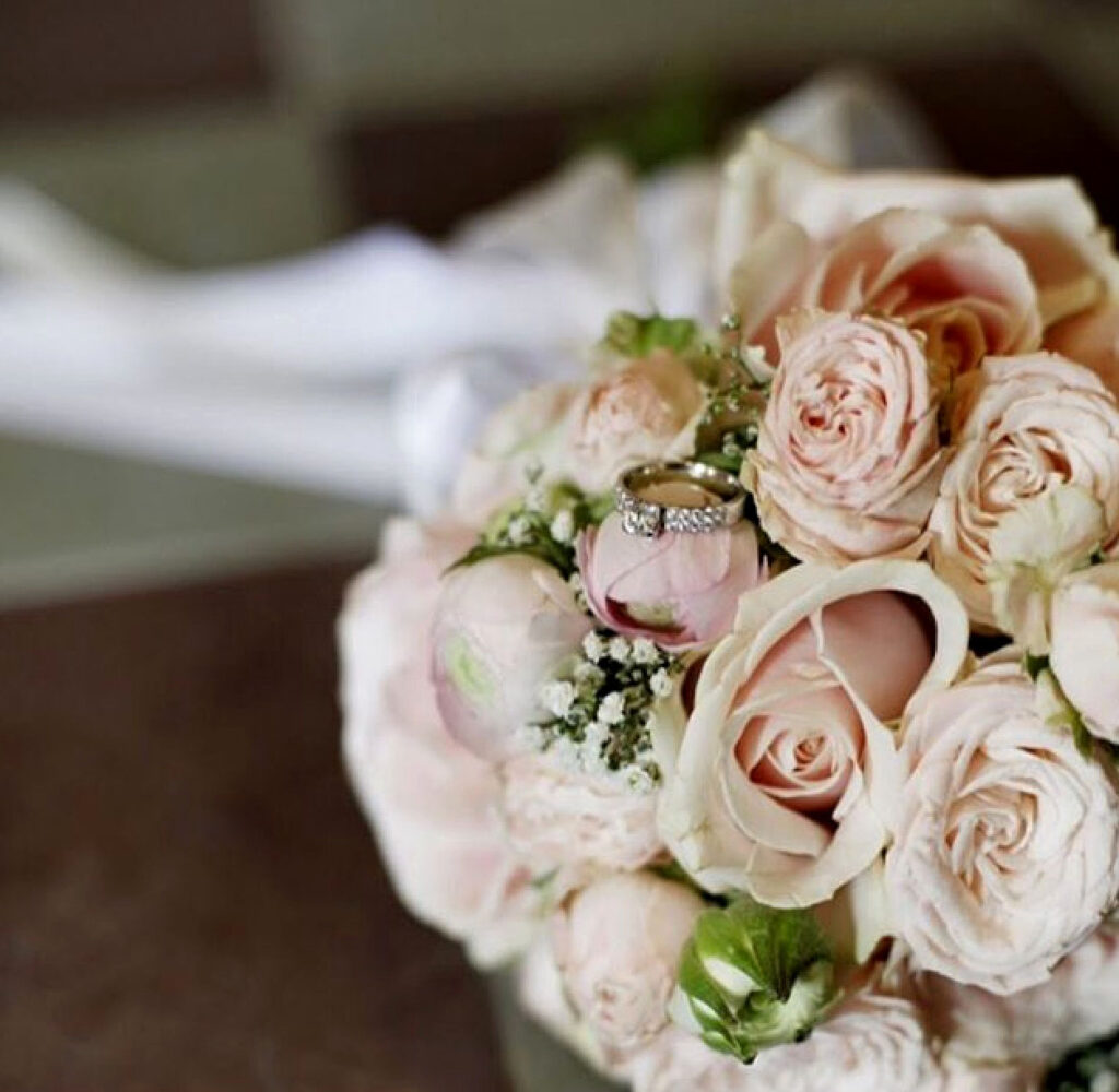 En vacker brudbukett med säsongens blommor i naturliga färger, arrangerad av professionella florister.