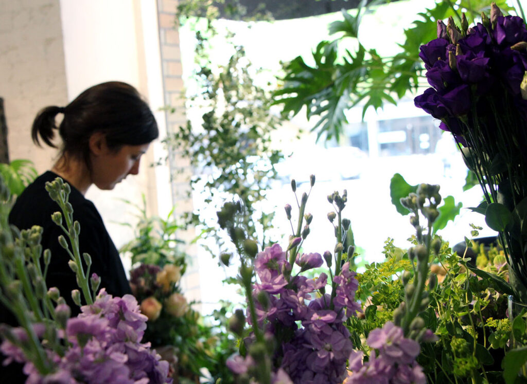 En vacker brudbukett med säsongens blommor i naturliga färger, arrangerad av professionella florister.